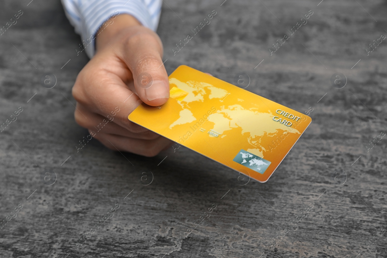 Photo of Young woman holding credit card over table