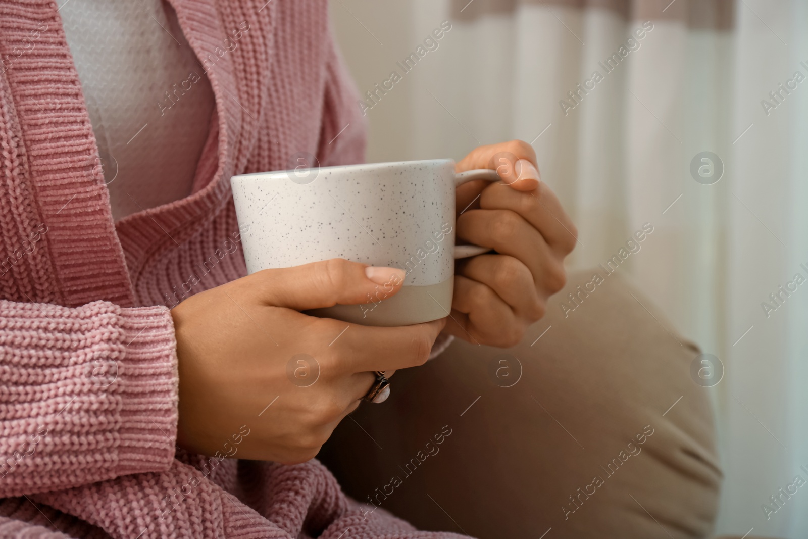 Photo of Woman holding elegant cup at home, closeup