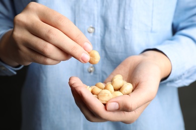 Photo of Woman holding shelled organic Macadamia nuts, closeup