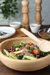 Delicious salad with beef tongue, vegetables and spoon served on wooden table