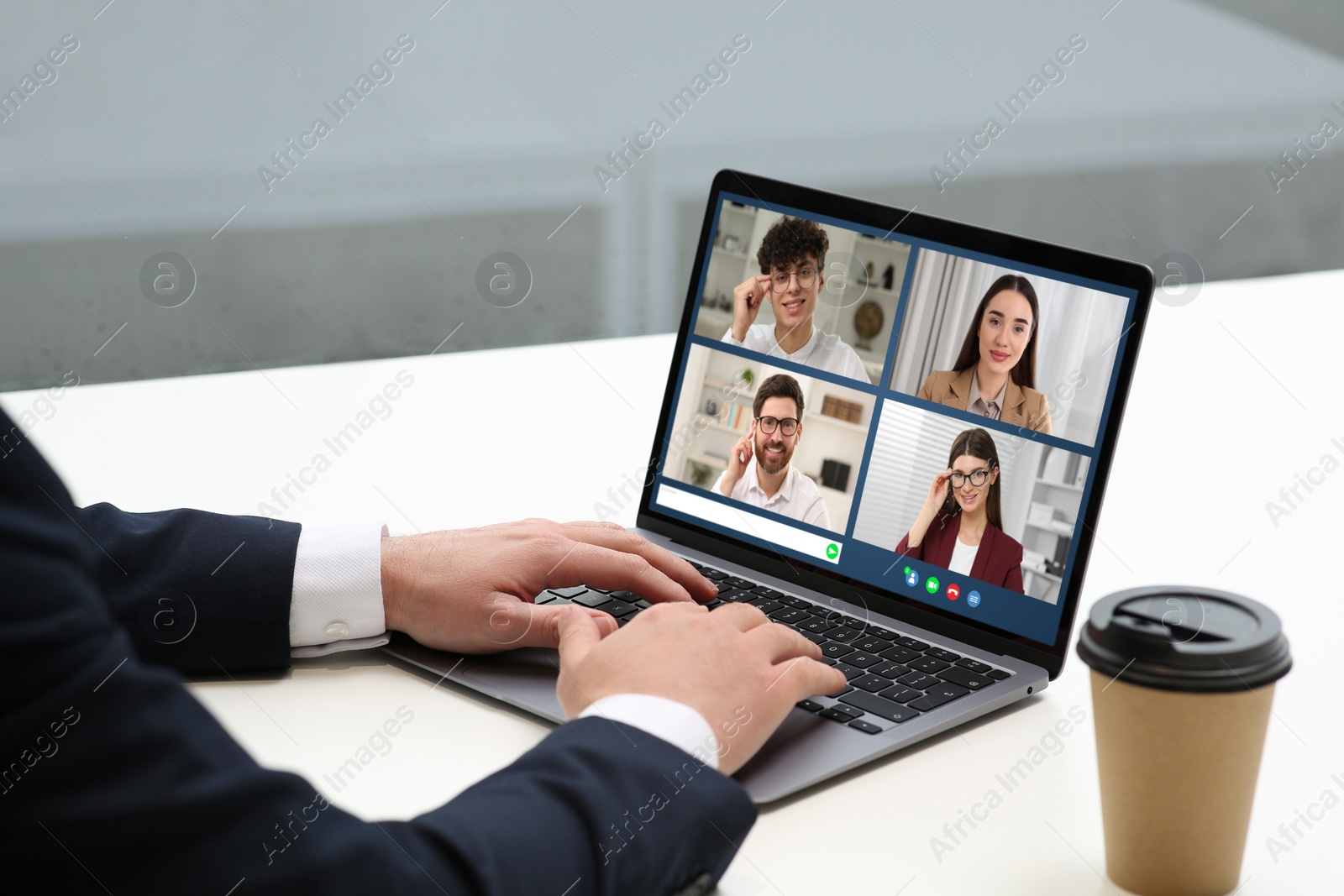 Image of Man having video chat with coworkers via laptop at white table, closeup