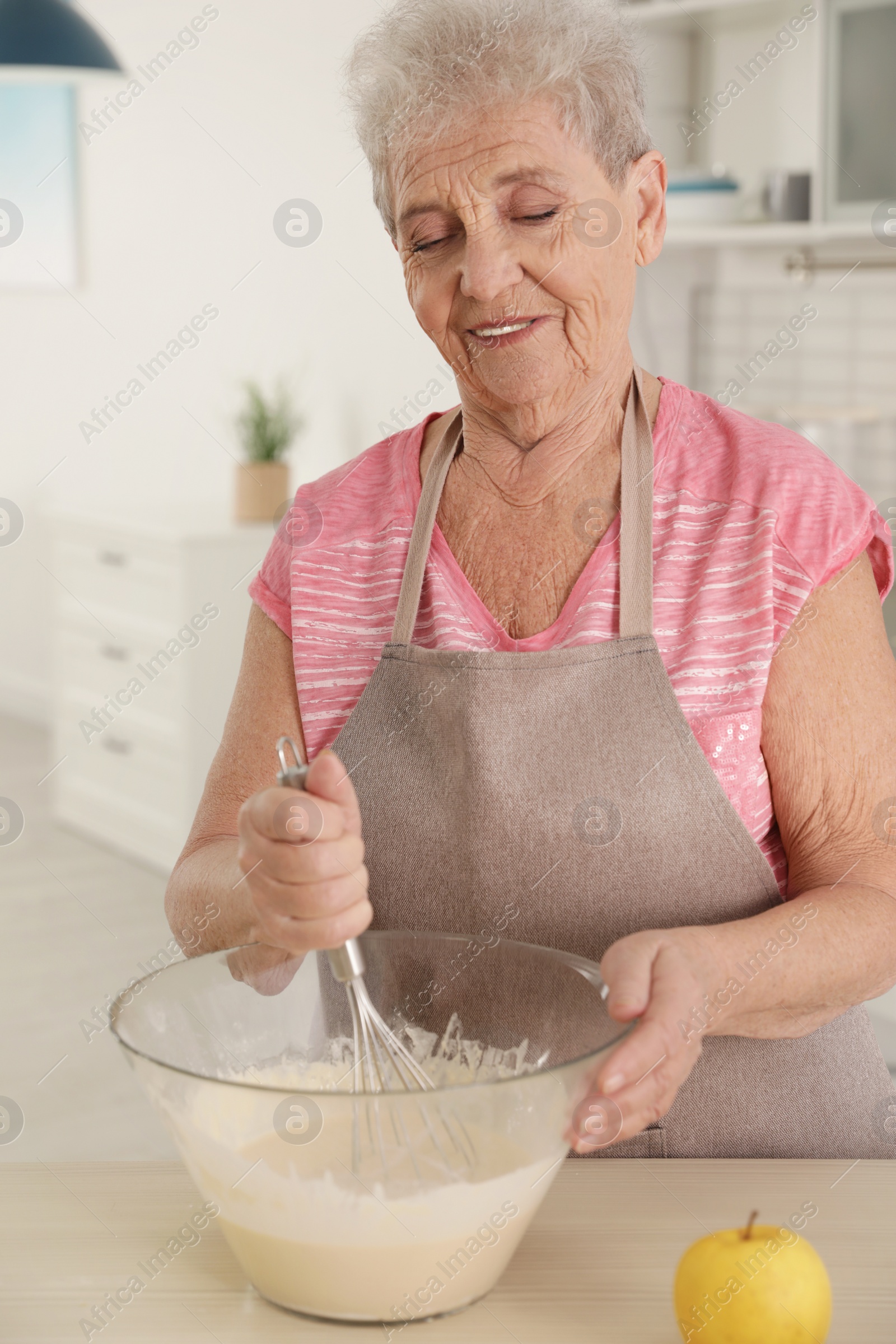 Photo of Portrait of beautiful grandmother cooking in kitchen