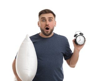 Photo of Emotional overslept man with alarm clock and pillow on white background. Being late concept
