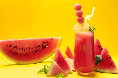 Photo of Tasty watermelon drink and fresh fruits on yellow background