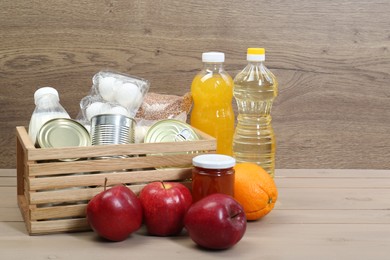 Photo of Different donation food on wooden table, space for text