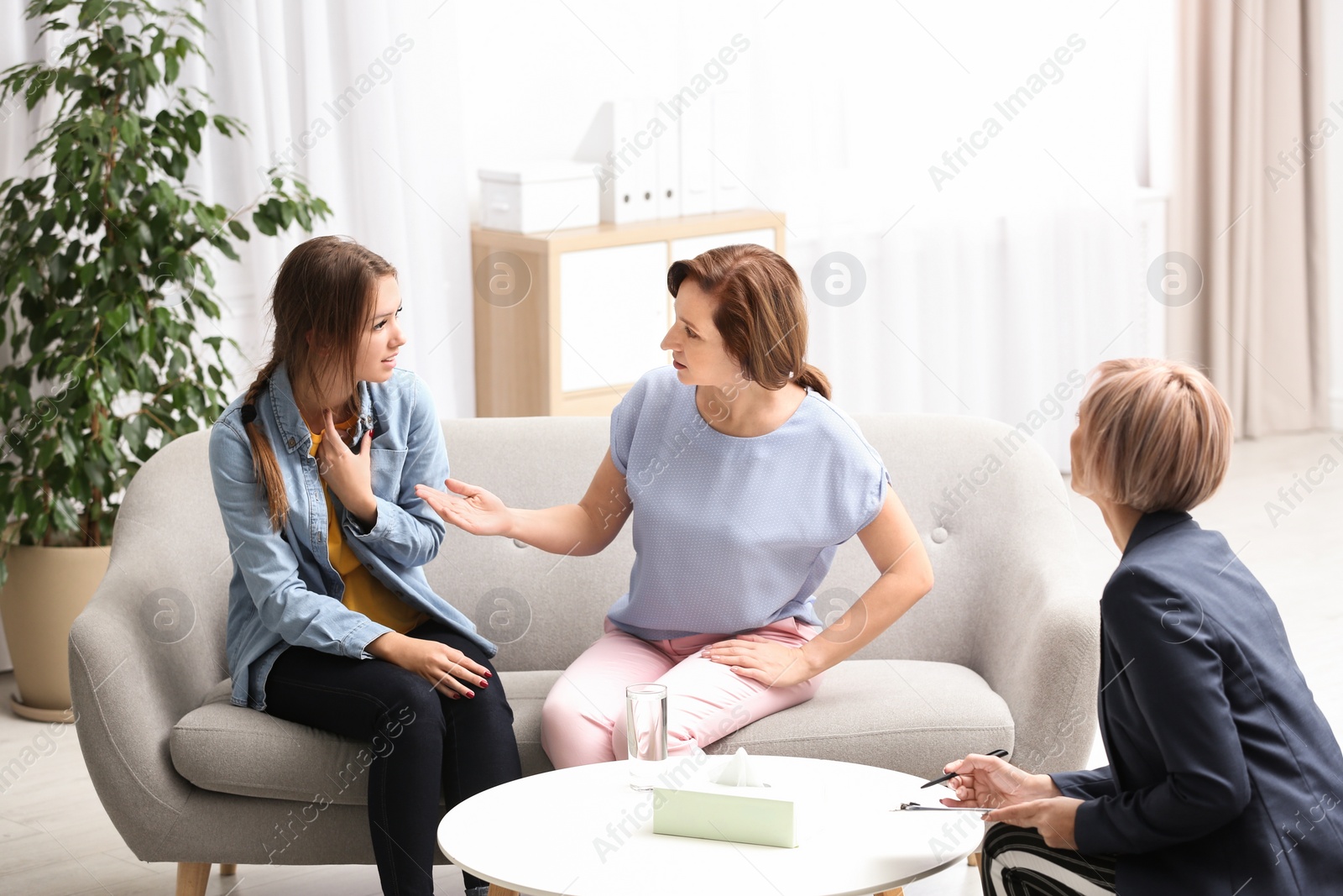 Photo of Psychotherapist working with teenage girl and her mother in office