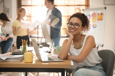 Photo of Portrait of happy female designer in office