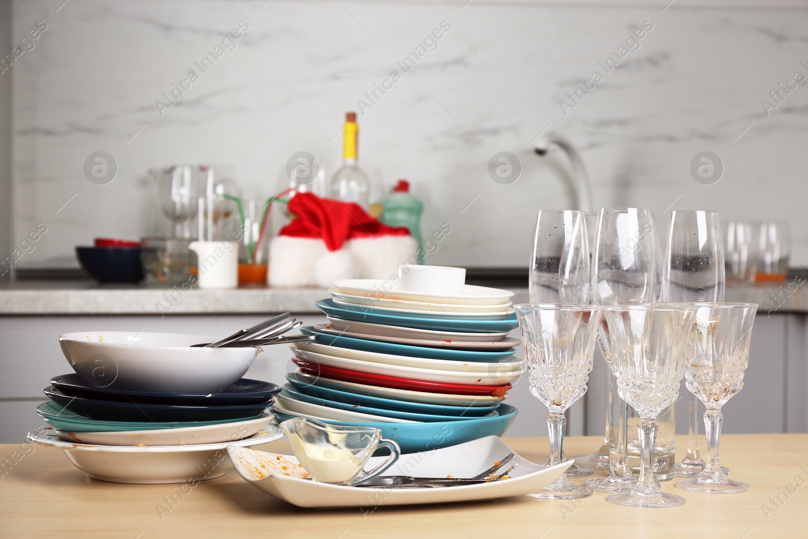 Photo of Dirty dishes and glasses on wooden table in kitchen after party