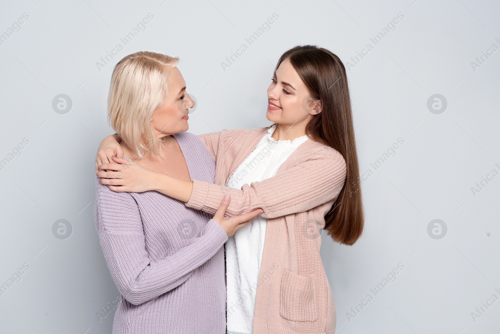 Photo of Portrait of mature woman and her daughter on color background