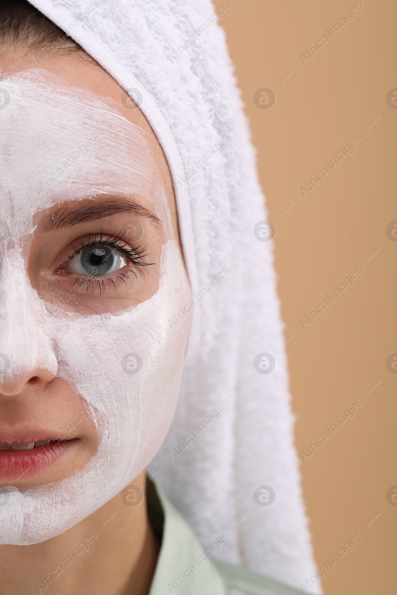 Photo of Woman with face mask on beige background, closeup and space for text. Spa treatments