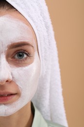 Woman with face mask on beige background, closeup and space for text. Spa treatments