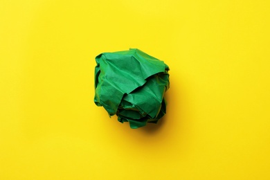 Crumpled sheet of paper on color background, top view