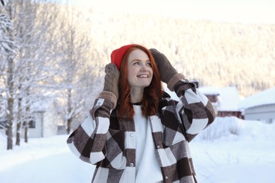 Photo of Portrait of beautiful young woman on snowy day outdoors. Winter vacation