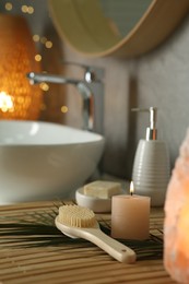 Photo of Composition with different spa products and burning candle on countertop in bathroom