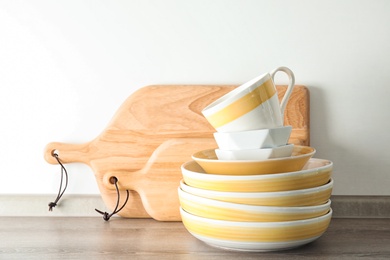 Photo of Set of dishware on table against light background. Interior element