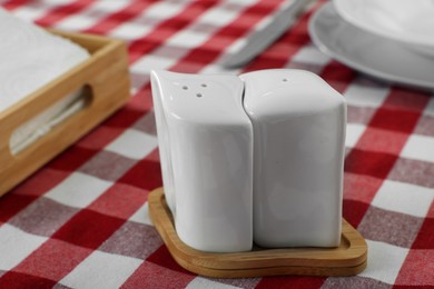 Ceramic salt and pepper shakers on kitchen table, closeup