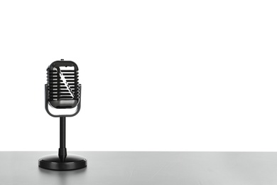 Retro microphone on table against white background. Space for text