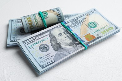 Photo of Many dollar banknotes on white table, closeup