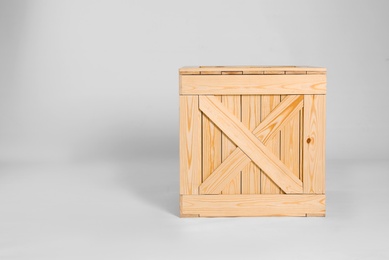 Photo of Closed wooden crate on grey background. Space for text