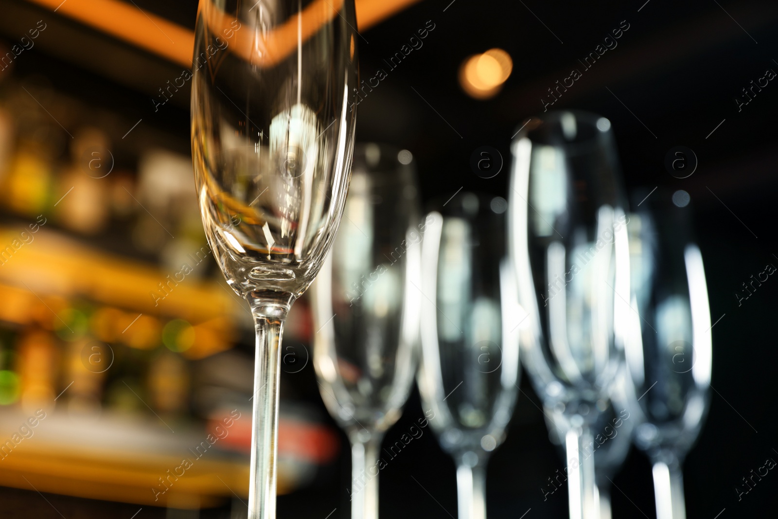 Photo of Empty clean champagne glass in bar, closeup. Space for text