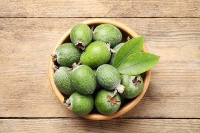 Photo of Top view of fresh green feijoa fruits in bowl on wooden table