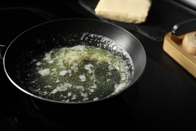 Photo of Melting butter in frying pan on cooktop