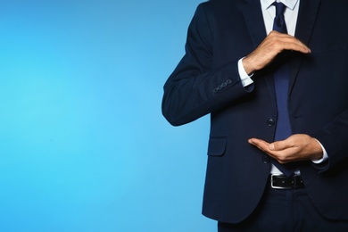 Businessman holding something on color background, closeup view of hands with space for text