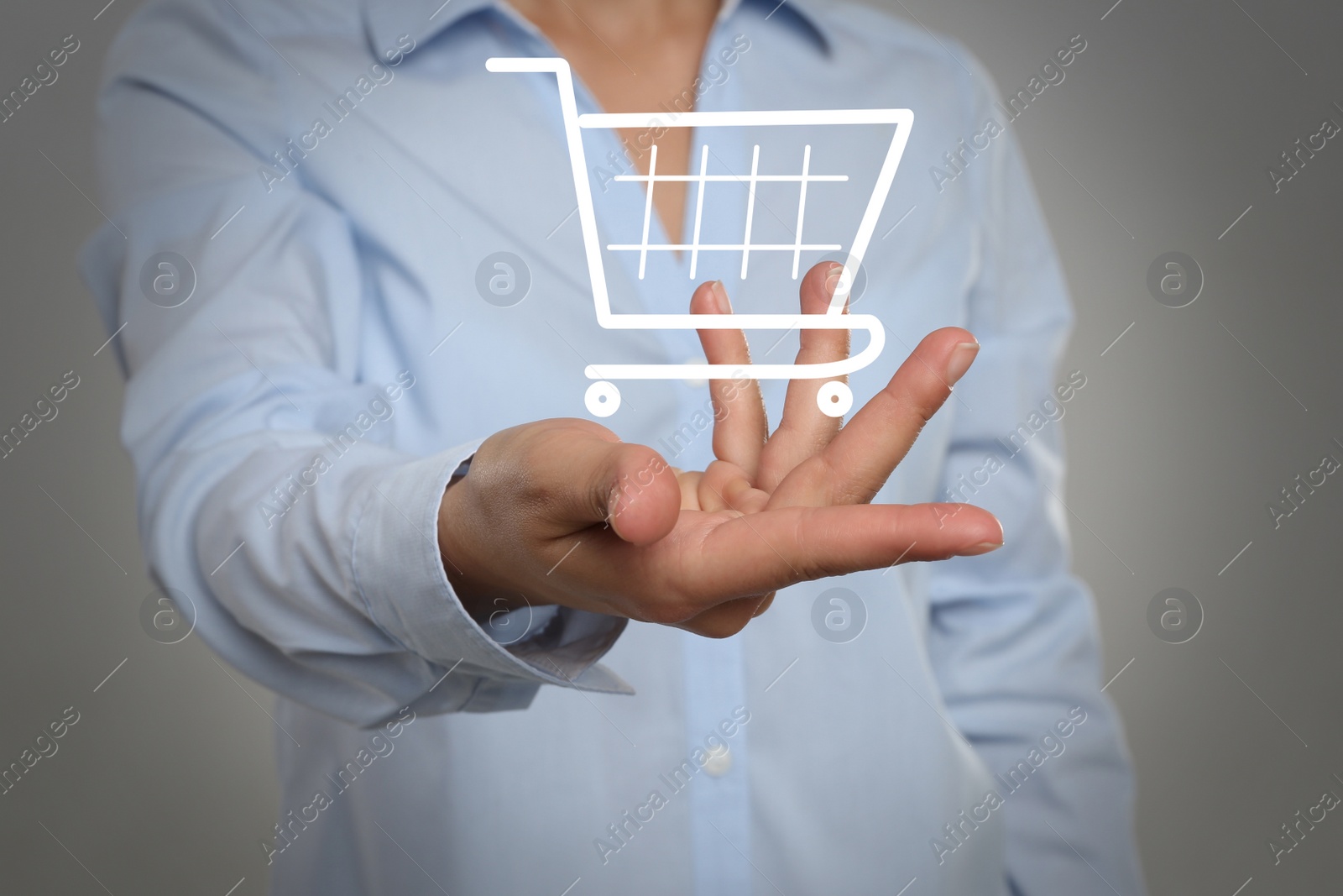 Image of Woman demonstrating virtual image of shopping cart on light grey background, closeup