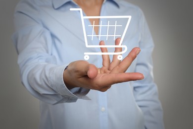 Image of Woman demonstrating virtual image of shopping cart on light grey background, closeup