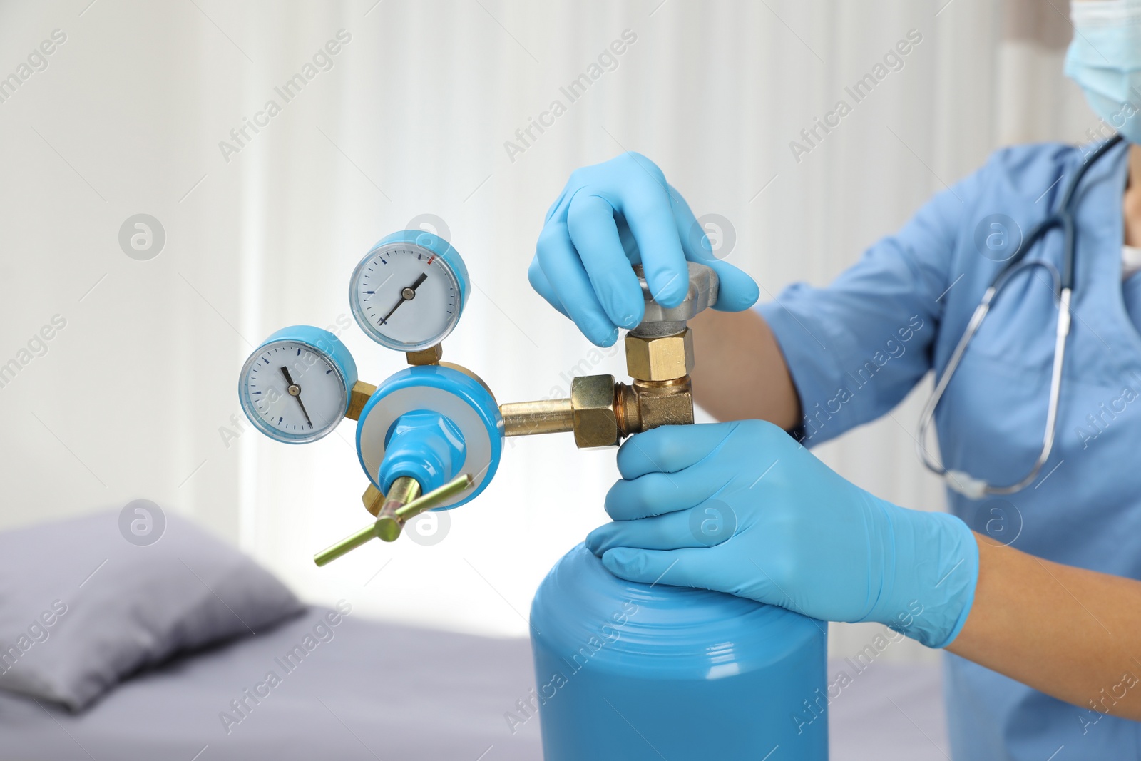 Photo of Medical worker checking oxygen tank in hospital room, closeup