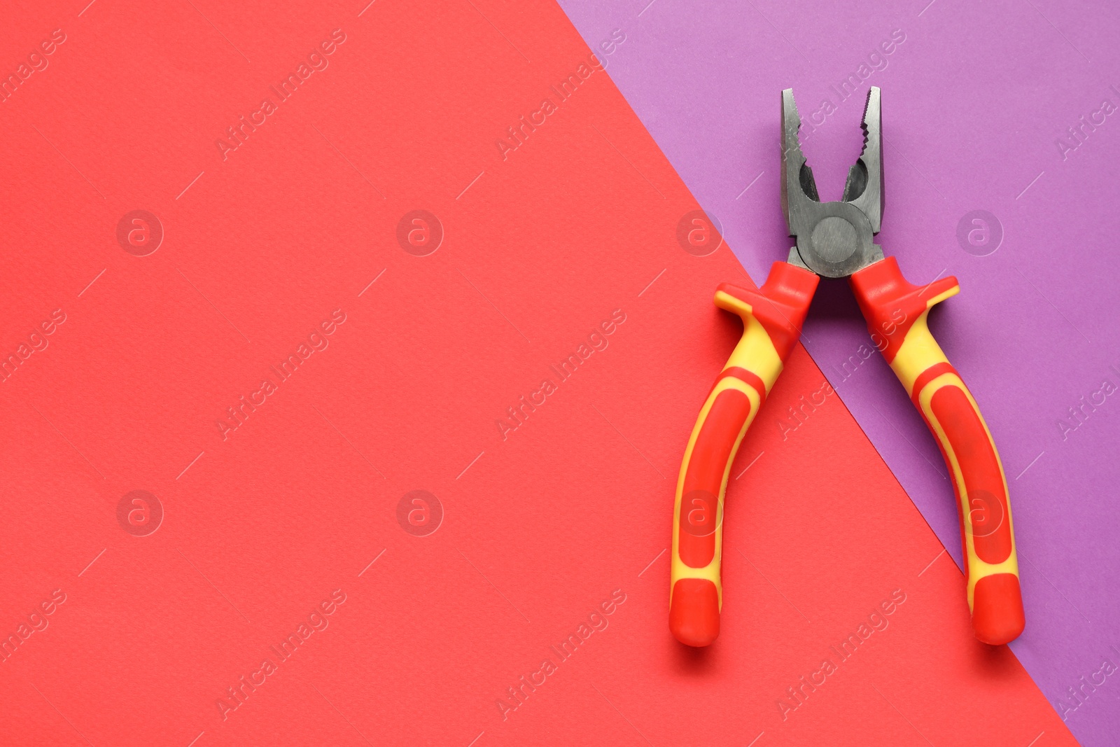 Photo of Combination pliers on color background, top view. Space for text