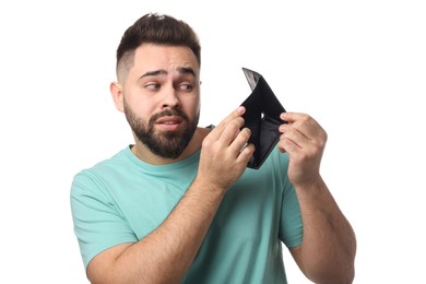 Photo of Confused man showing empty wallet on white background
