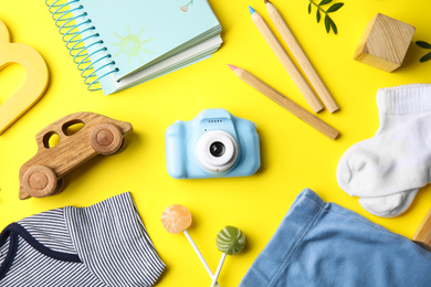 Photo of Flat lay composition with toy camera on yellow background. Future photographer