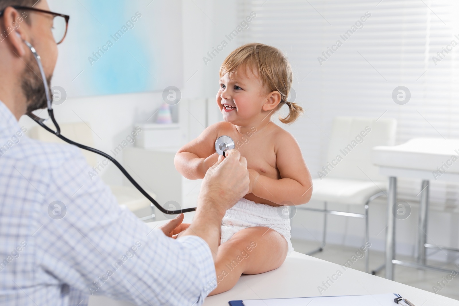 Photo of Pediatrician examining baby with stethoscope in clinic