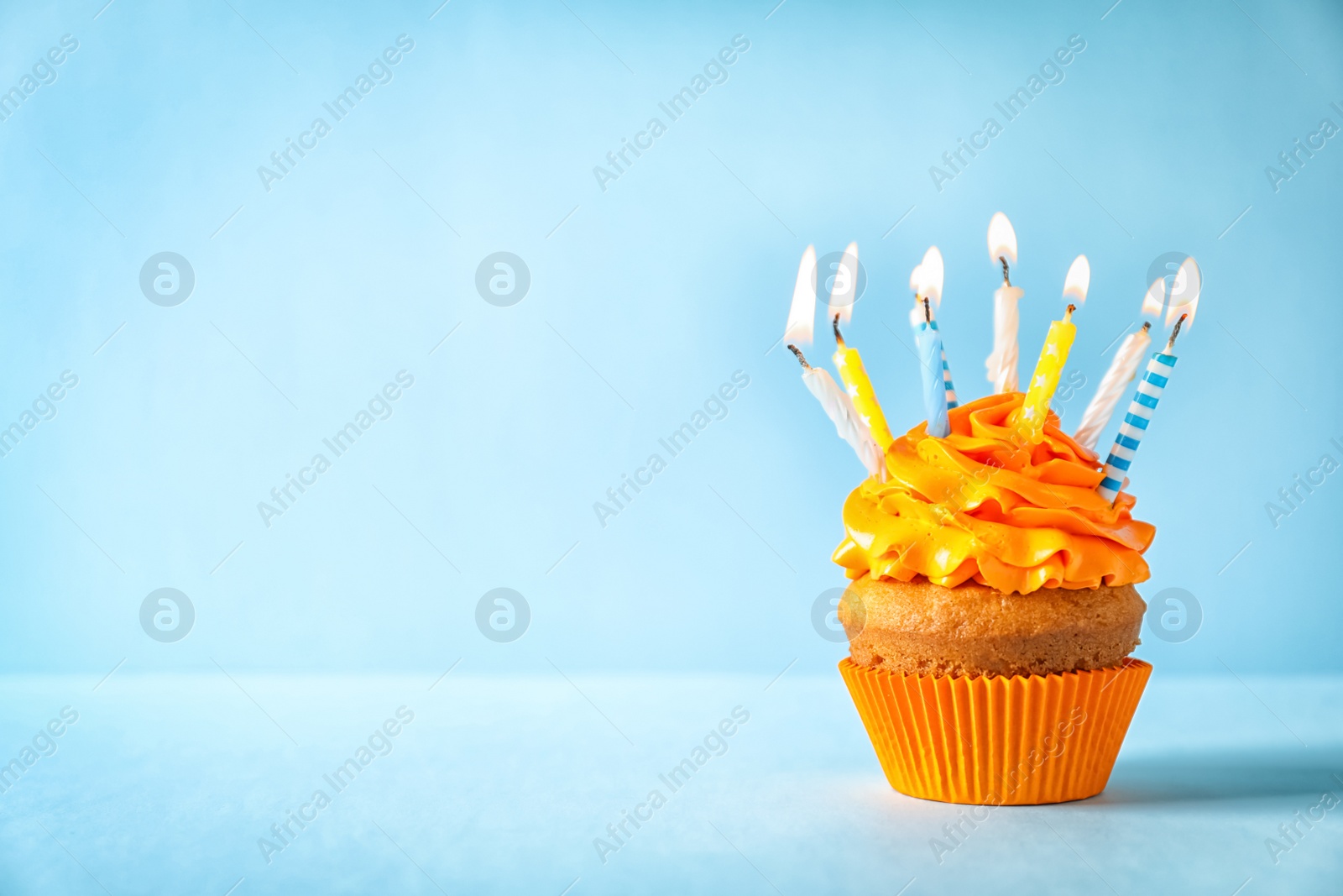 Photo of Delicious birthday cupcake with candles on color background