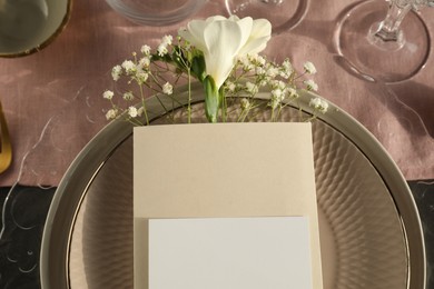 Photo of Stylish table setting. Plates, blank card and floral decor, top view