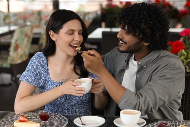 International dating. Happy couple spending time together in restaurant