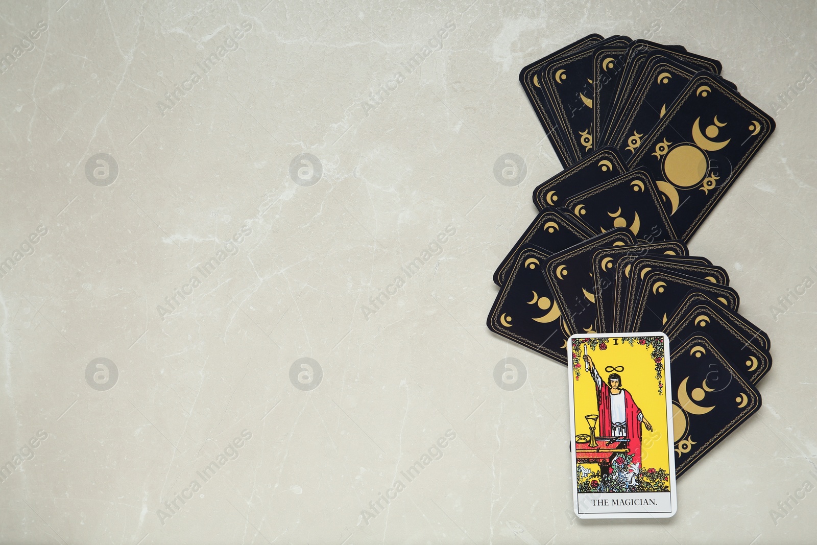 Photo of The Magician and other tarot cards on light table, flat lay. Space for text