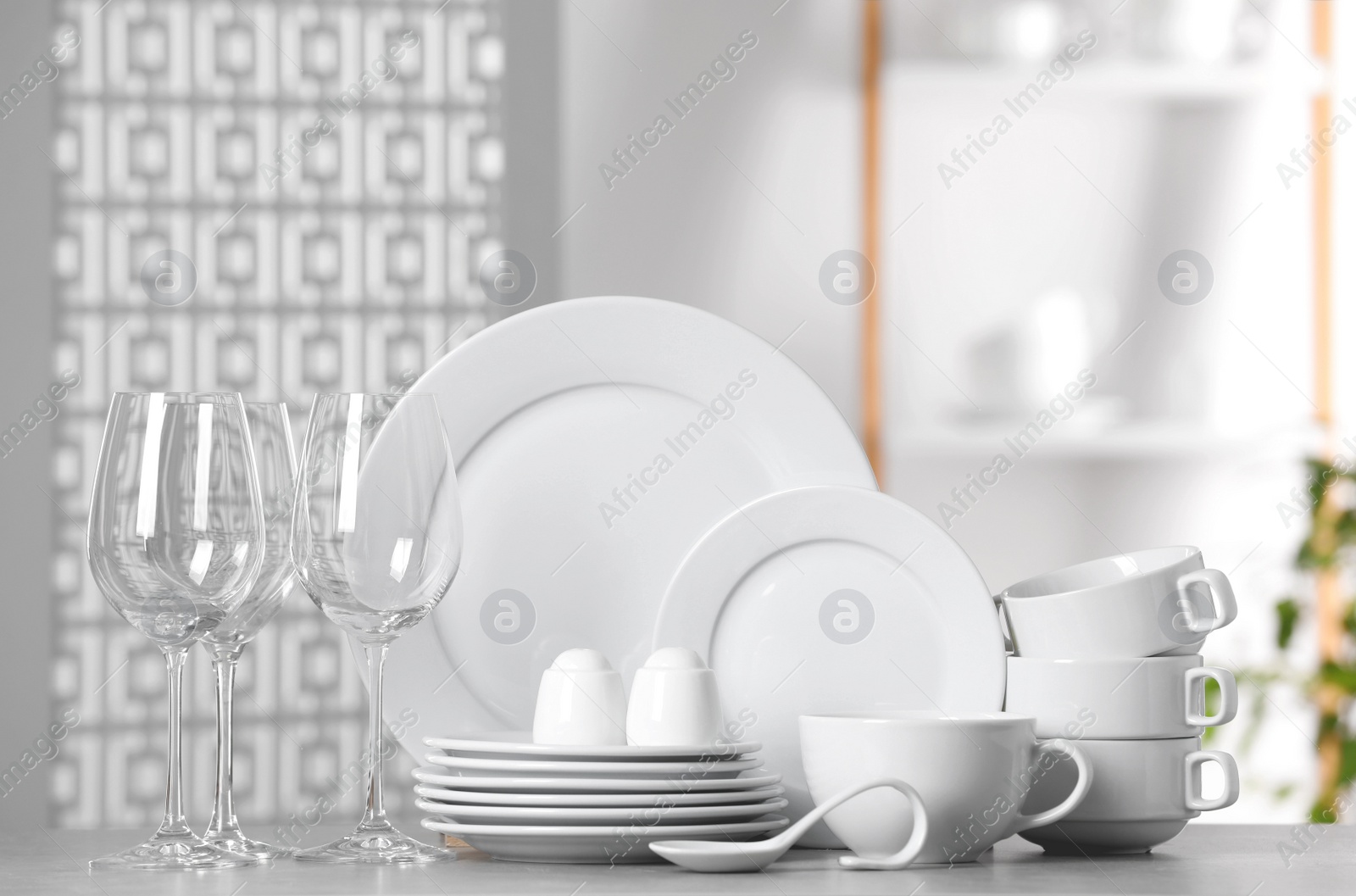 Photo of Set of clean dishware and glasses on light table
