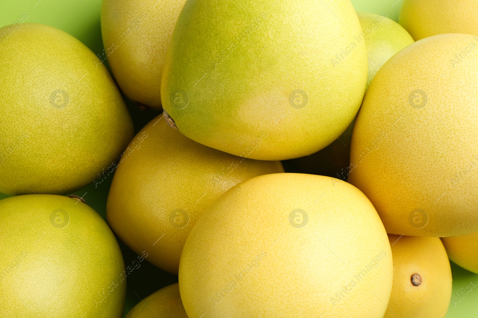 Photo of Fresh pomelo fruits on green background, closeup