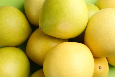 Photo of Fresh pomelo fruits on green background, closeup