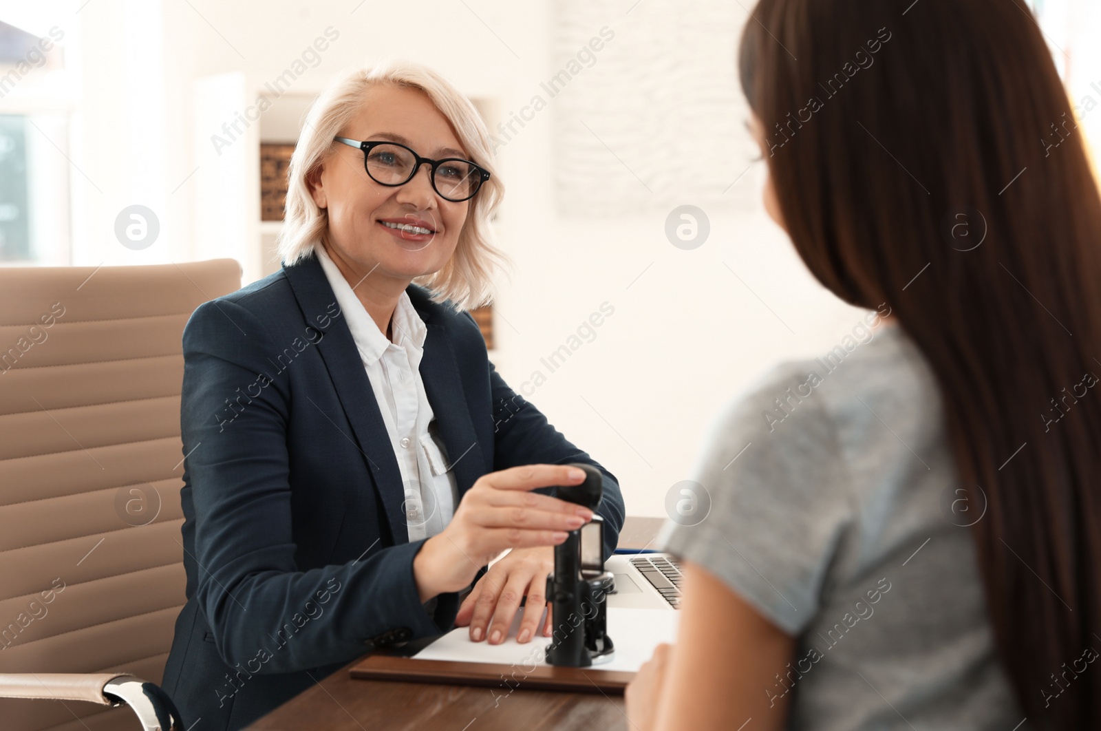 Photo of Female notary working with client in office