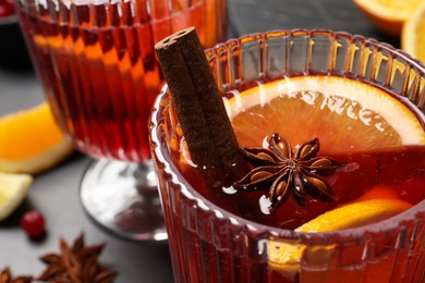 Photo of Glass with aromatic punch drink on table, closeup view