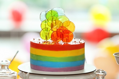 Bright birthday cake on table in decorated room