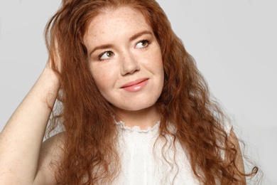 Portrait of young woman with beautiful face on grey background, closeup