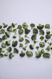 Many fresh green broccoli pieces on white background, flat lay