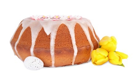 Photo of Festively decorated Easter cake, painted egg and yellow tulips on white background