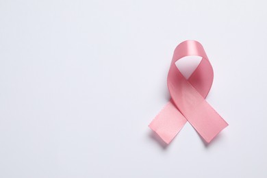 Pink ribbon on white background, top view and space for text. Breast cancer awareness