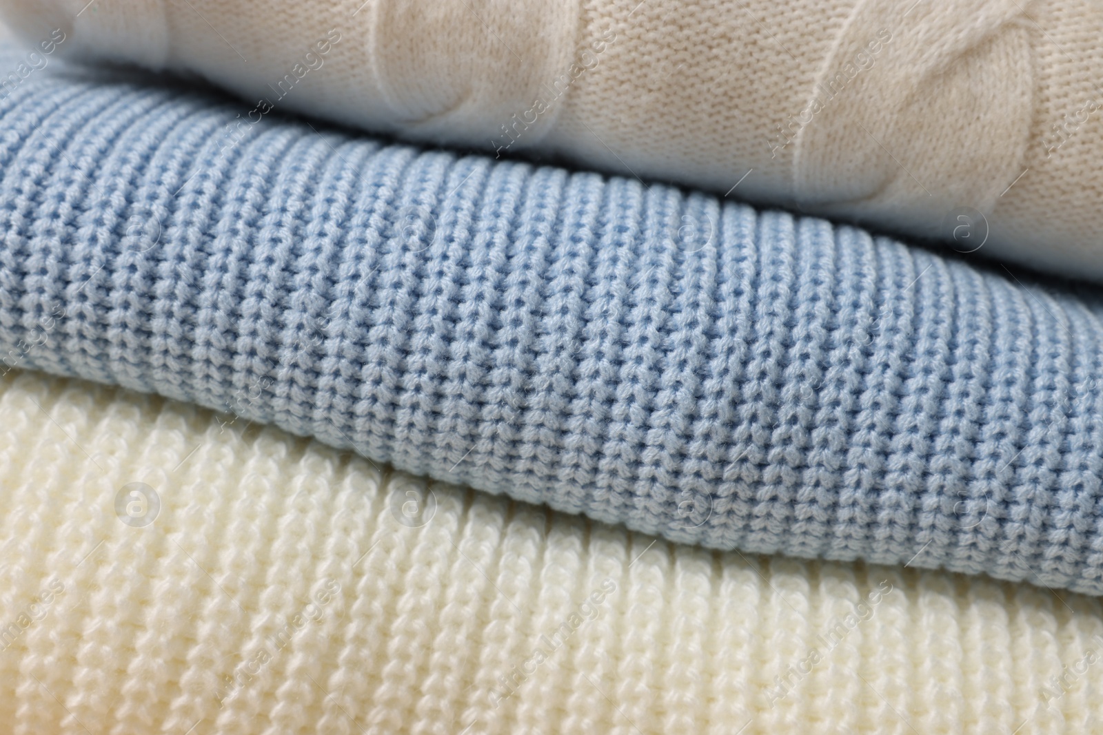 Photo of Closeup view of different warm folded sweaters as background