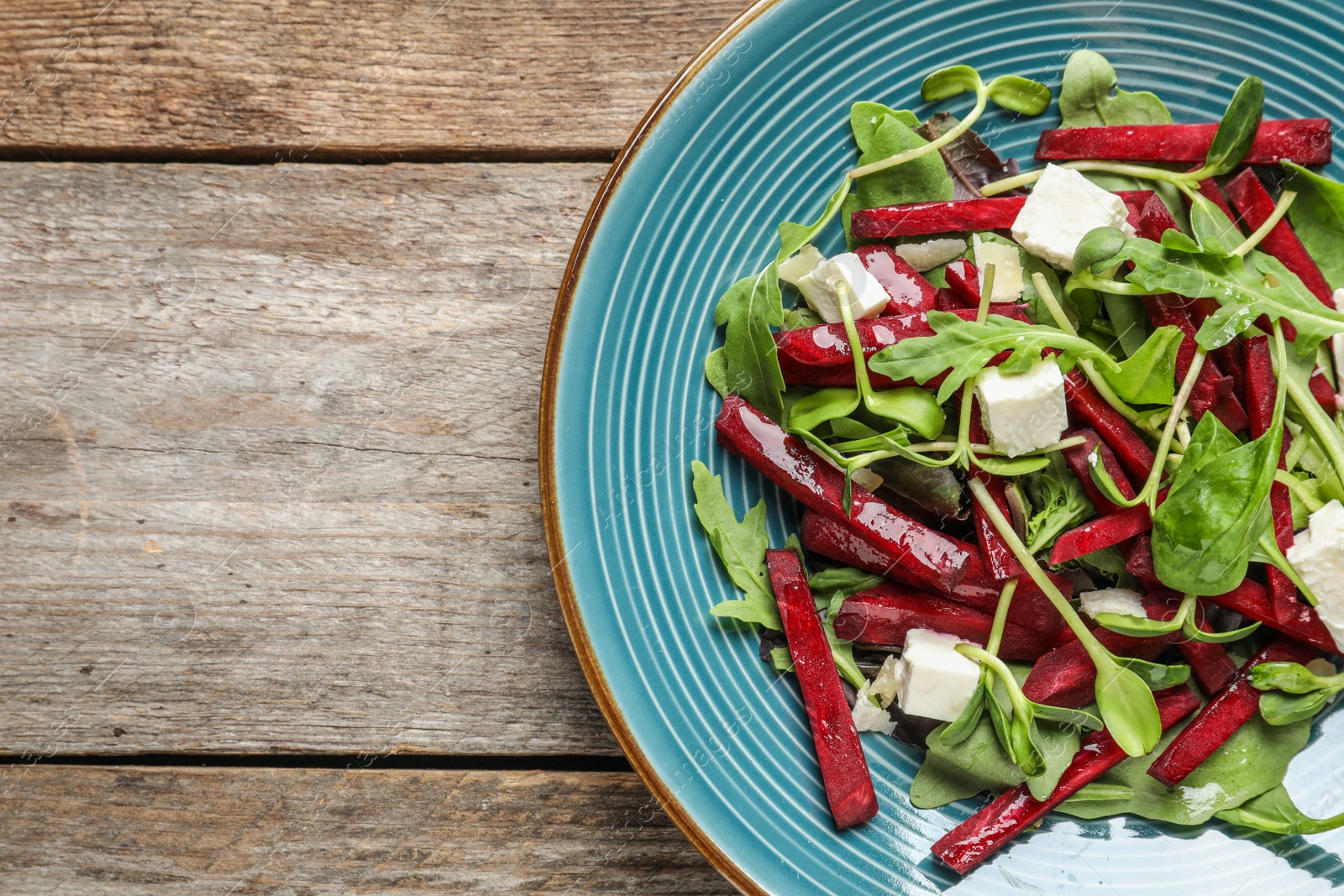 Photo of Plate with delicious beet salad on wooden background, top view